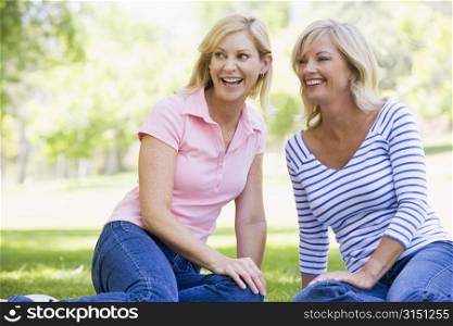 Two women sitting outdoors smiling