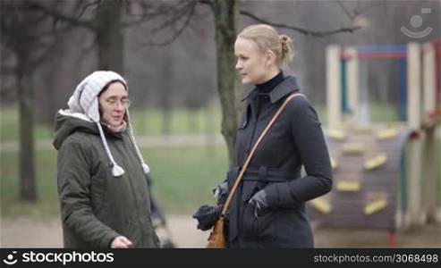 Two women talking outdoor. Friends or neighbours having conversation.