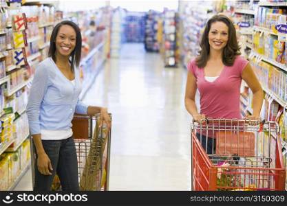 Two women talking to each other at a grocery store