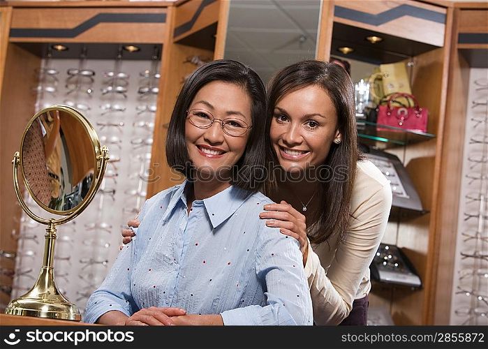 Two women trying on eyeglasses in store