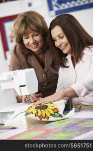 Two Women Using Electric Sewing Machine