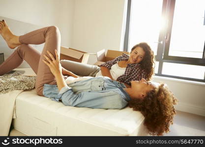 Two Women With Boxes In Bedroom Moving Into New Home