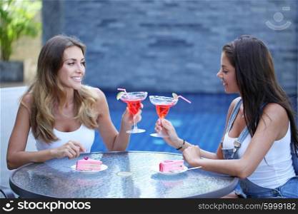 Two women with cocktails. Two young women with cocktails outdoors at cafe