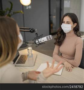 two women with medical mask conversing radio