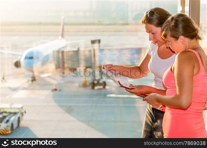 two women with tickets on the background of the aircraft