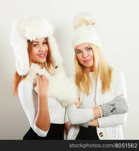 Two women with winter clothes.. Fashion models people concept. Two women with winter clothes. Blonde and mixed race ladies wearing warm clothing.