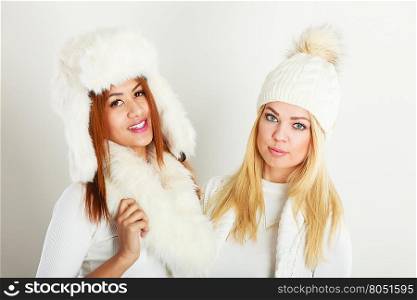 Two women with winter clothes.. Fashion models people concept. Two women with winter clothes. Blonde and mixed race ladies wearing warm clothing.