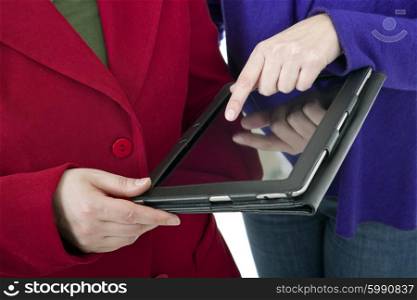Two women working with a digital tablet, detail