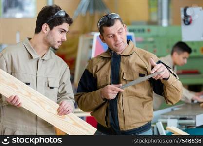 two wood designer working with laptop in workshop