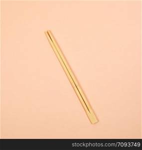 two wooden chopsticks on a beige background, close up