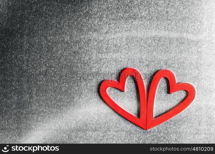 Two wooden hearts. Two red wooden hearts on metal background with copy space