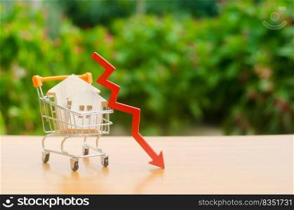 Two wooden houses in a trading cart and red arrow down. falling real estate market. Reduced interest in the mortgage. A decline in property prices and apartments. Low interest rates on mortgage loans.