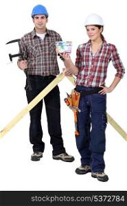 Two woodworker stood with money