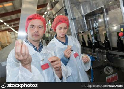 two workers analyzing a cork stopper of a bottle