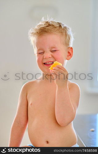 Two year old boy eating sour fruit