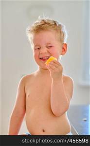 Two year old boy eating sour fruit
