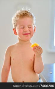 Two year old boy eating sour fruit