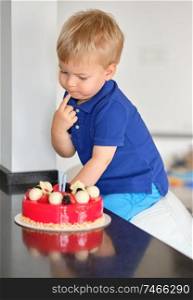 Two year old boy trying birthday cake 