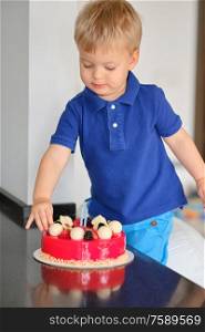 Two year old boy trying birthday cake