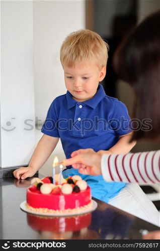 Two year old boy with birthday cake