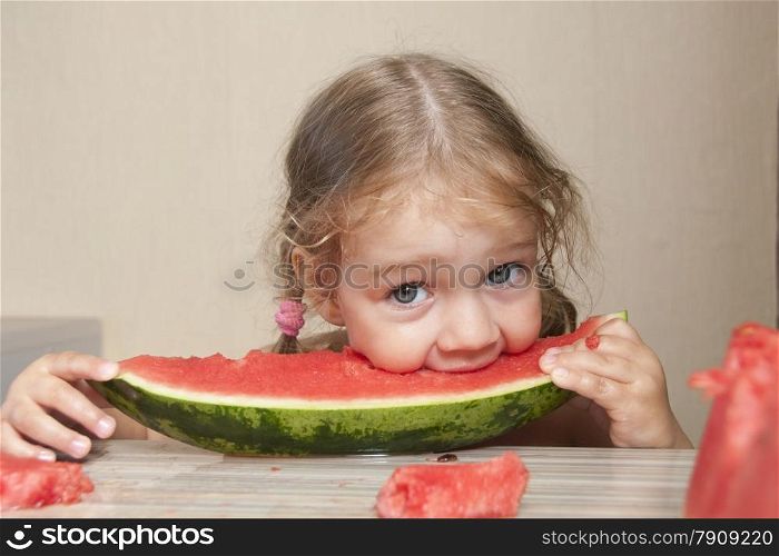 Two-year-old girl eating watermelon with cheerful faces