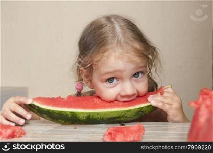 Two-year-old girl eating watermelon with cheerful faces