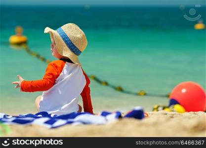 Two year old toddler boy in sun hat beach