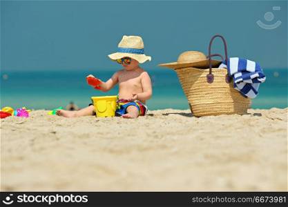 Two year old toddler playing on beach. Two year old toddler boy playing with beach toys on beach