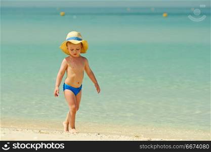 Two year old toddler playing on beach. Two year old toddler boy playing on beach