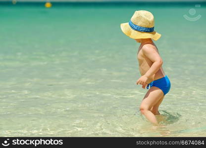 Two year old toddler playing on beach. Two year old toddler boy playing on beach