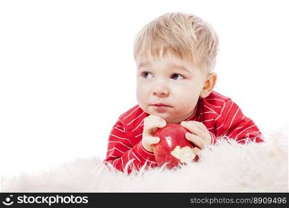 Two years Boy eating red apple isolated on white. Boy eating apple