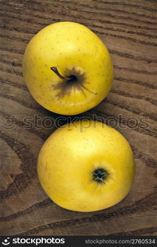 Two yellow apples on a wooden plank. Clipping path is included