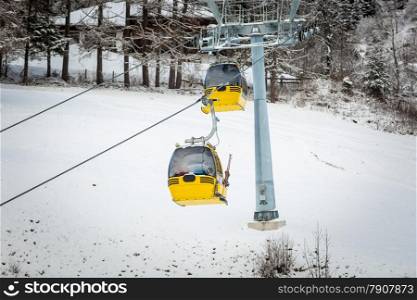 Two yellow cable cars on ski slope at Austrian Alps