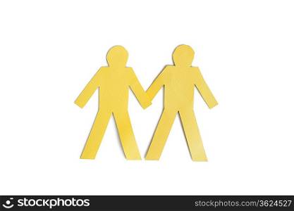Two yellow paper cut out figures holding hands over white background