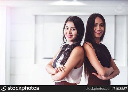 Two young Asian businesswomen sitting in office. Business friends and community concept.