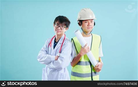 Two young asian teenager wear Doctor and Engineer suit posing in front of camera .Dreams and education concept .