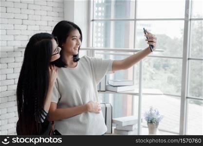 Two young Asian women selfie with mobile phones.Best friend relationship concept.
