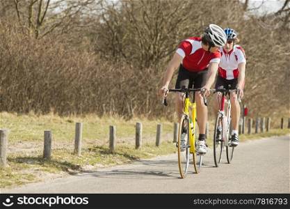 Two young athlete riding bicycles on a country road