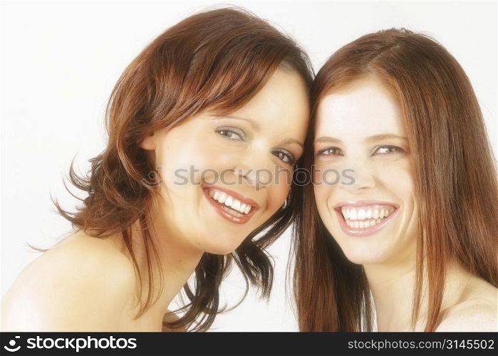Two young Australian women in studio smiling at eachother.