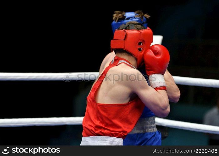 Two young boxers compete in a boxing ring 
