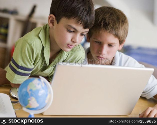 Two Young Boys Using A Laptop At Home