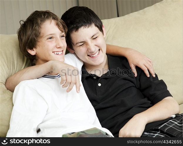Two young brothers laughing together at home.