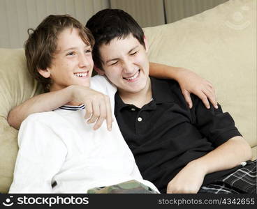 Two young brothers laughing together at home.