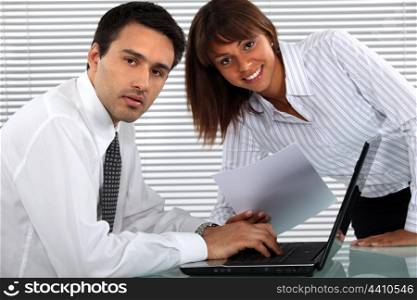 Two young business people working all hours to finish project