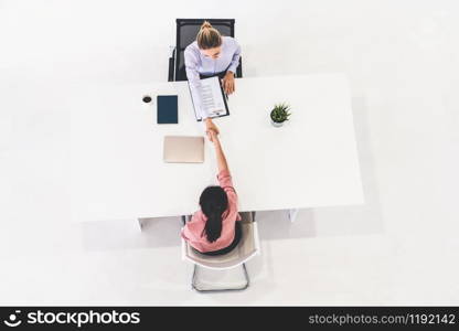 Two young business women in meeting at office table for job application and business agreement. Recruitment and human resources concept.