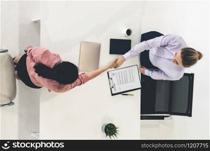 Two young business women in meeting at office table for job application and business agreement. Recruitment and human resources concept.. Two young business women meeting for interview.