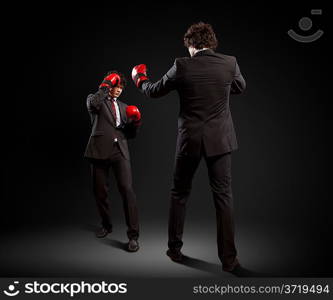 Two young businessman boxing