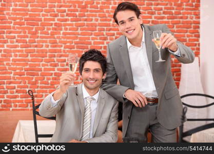 Two young businessmen celebrating successful year