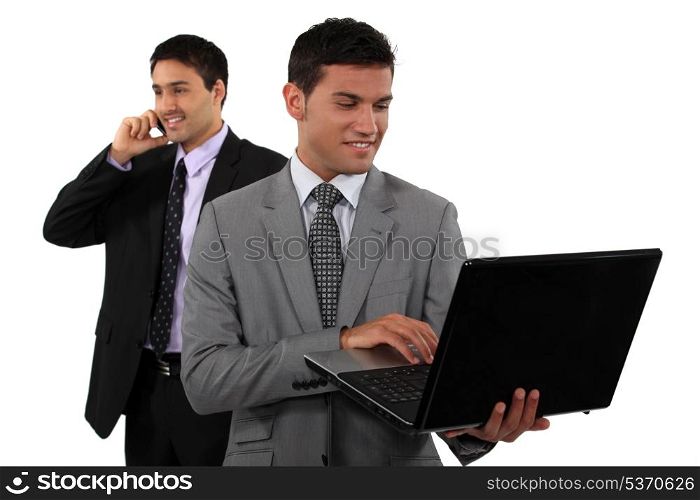 Two young businessmen embracing technology