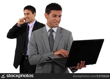 Two young businessmen embracing technology